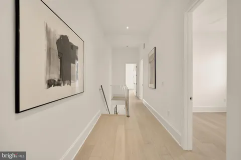 a view of a hallway with entryway wooden floor and staircase