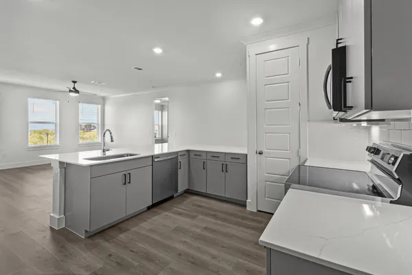 a kitchen with cabinets stainless steel appliances and wooden floor