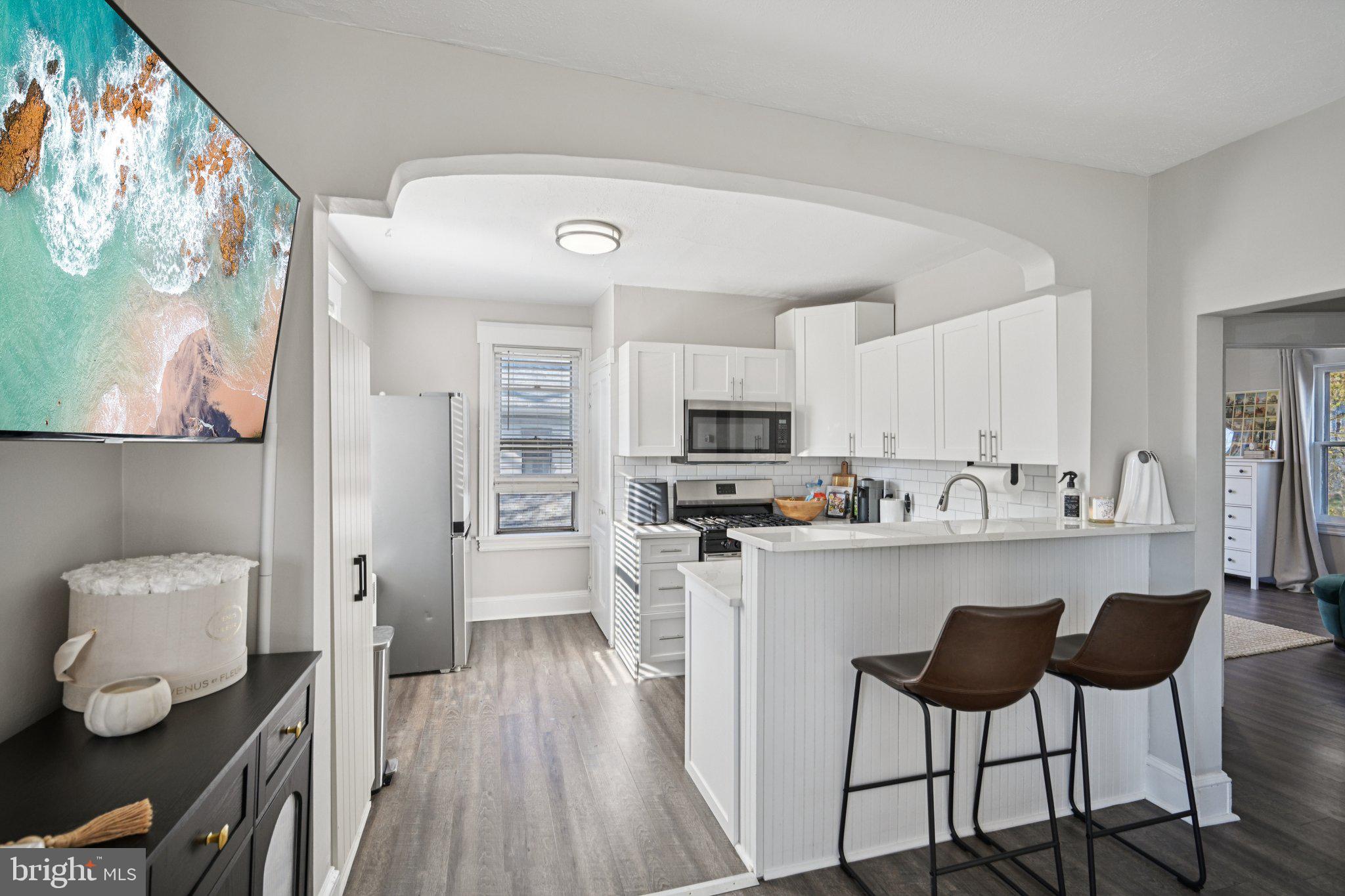 127 7th Avenue Haddon Heights, NJ 08035 - Photo 27 of 47 a kitchen with stainless steel appliances a dining table chairs refrigerator and sink