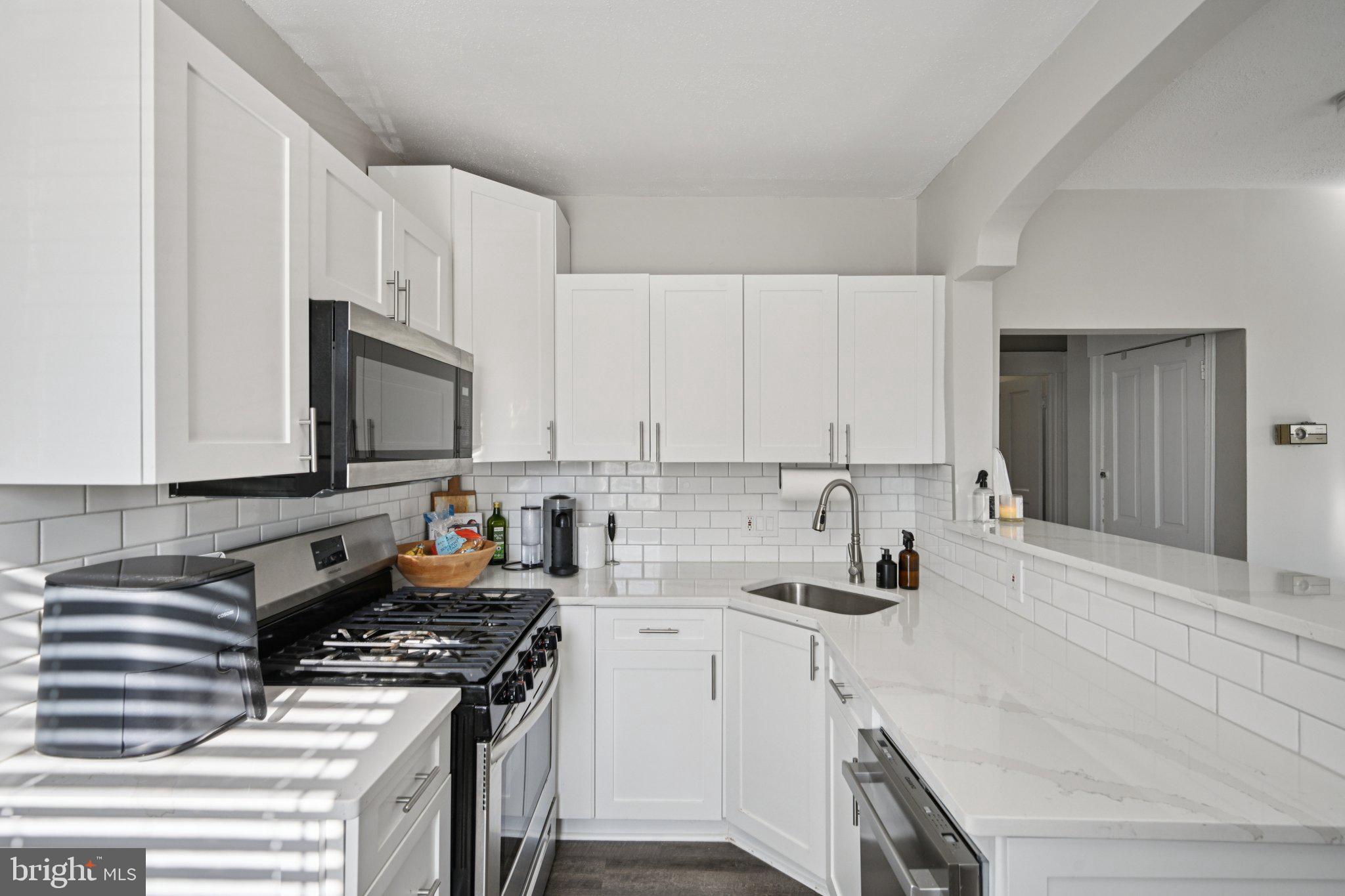 127 7th Avenue Haddon Heights, NJ 08035 - Photo 29 of 47 a kitchen with granite countertop a stove sink and cabinets