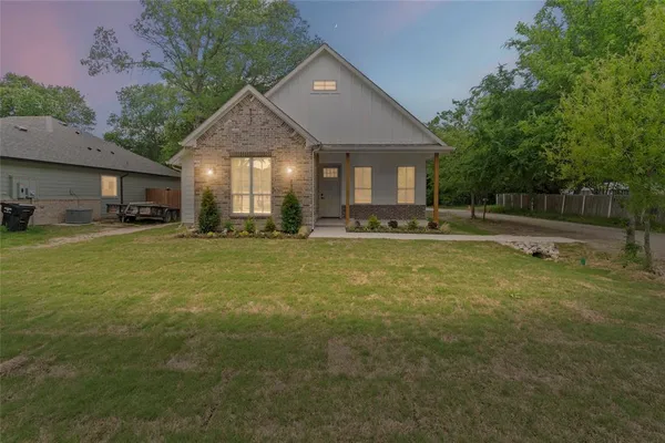 a view of a house with a yard and sitting area
