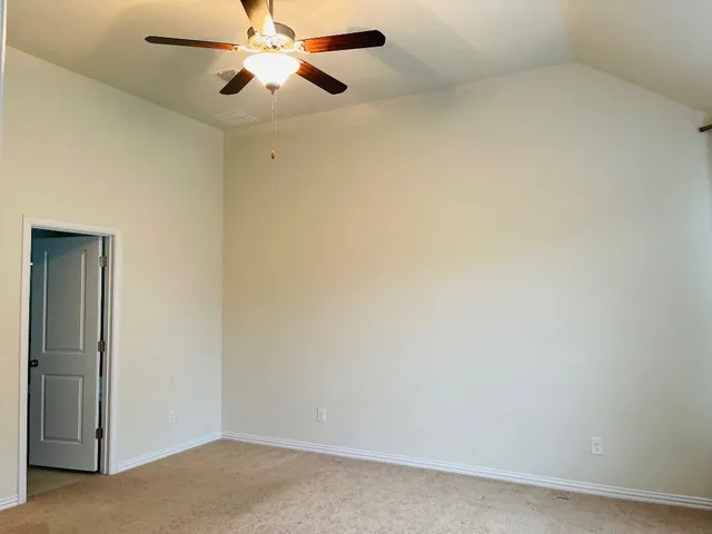 an empty room with a chandelier fan and a ceiling fan