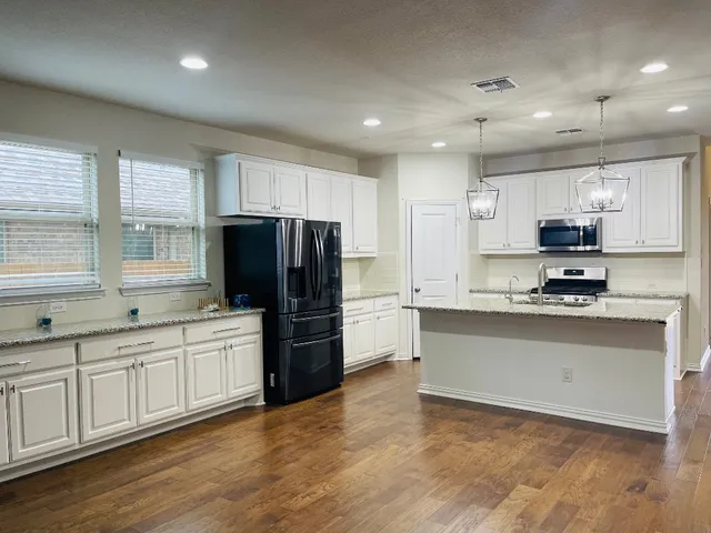 a kitchen with stainless steel appliances a refrigerator sink and microwave