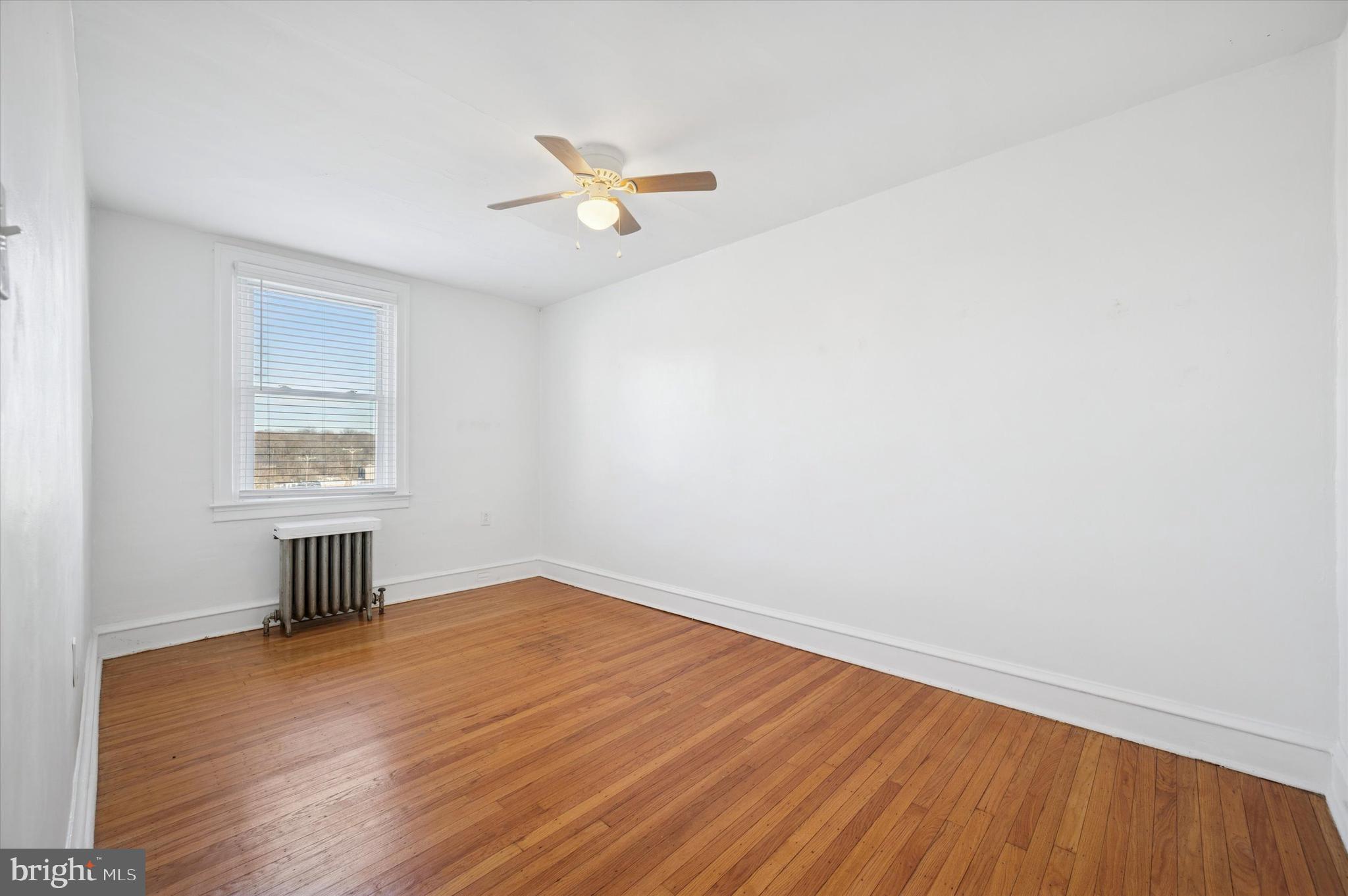 6207 Homer Street Philadelphia, PA 19144 - Photo 18 of 26 an empty room with wooden floor a ceiling fan and windows