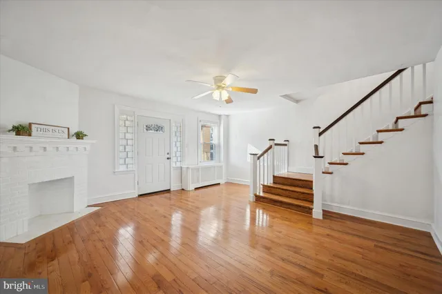 a view of a kitchen with wooden floor and a ceiling fan