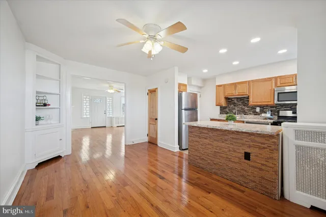 a kitchen with kitchen island granite countertop wooden cabinets and white appliances