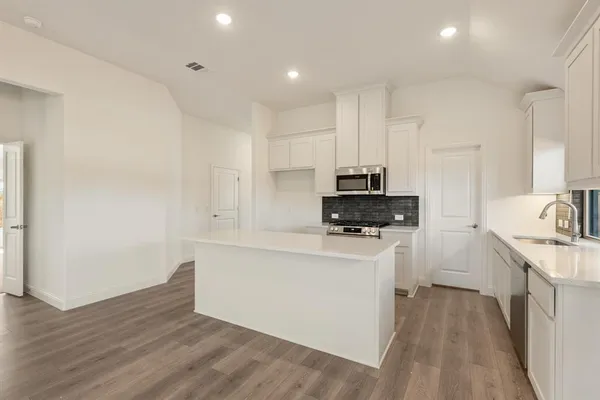 a kitchen with white cabinets and stainless steel appliances