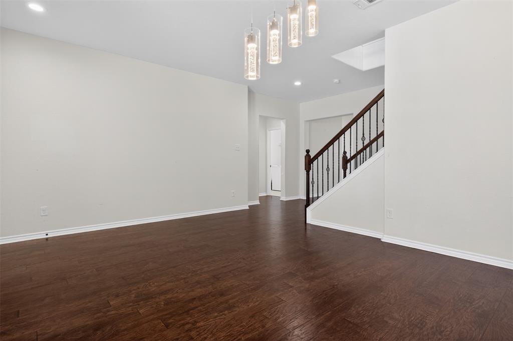 8728 Maple Ridge Trail Fort Worth, TX 76244 - Photo 10 of 40 Open-concept living space with dark wood-finish flooring, white baseboards, and neutral wall paint