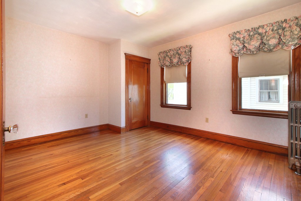 58-60 Matignon Road Cambridge, MA 02140 - Photo 13 of 16 an empty room with wooden floor and windows