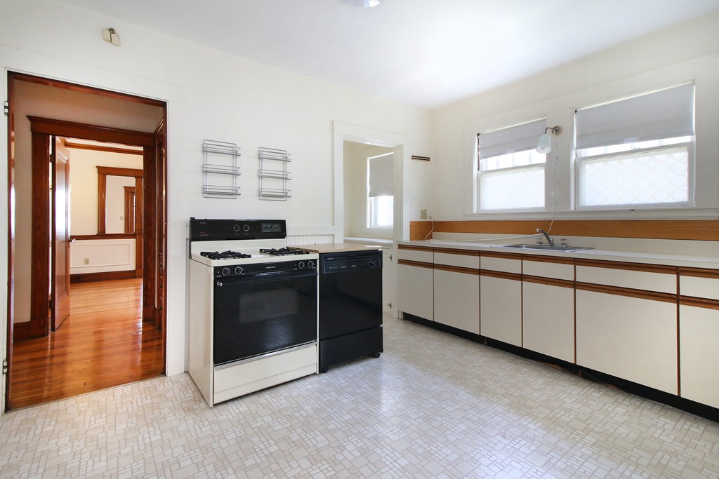 58-60 Matignon Road Cambridge, MA 02140 - Photo 3 of 16 a kitchen with stainless steel appliances granite countertop a stove and a refrigerator
