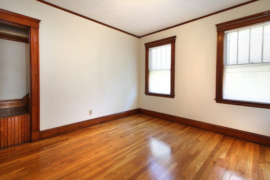 58-60 Matignon Road Cambridge, MA 02140 - Photo 4 of 16 a view of an empty room with wooden floor and a window