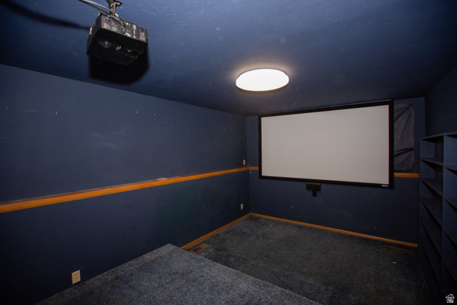 1500 Sumac Drive Logan, UT 84321 - Photo 35 of 42 Dedicated theater room featuring a large projection screen, ceiling-mounted projector, and built-in shelving