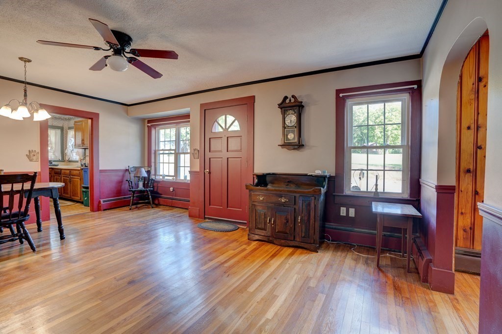 210 Belchertown Road Ware, MA 01082 - Photo 13 of 25 a living room with furniture a dining table a flat screen tv with wooden floor and a window