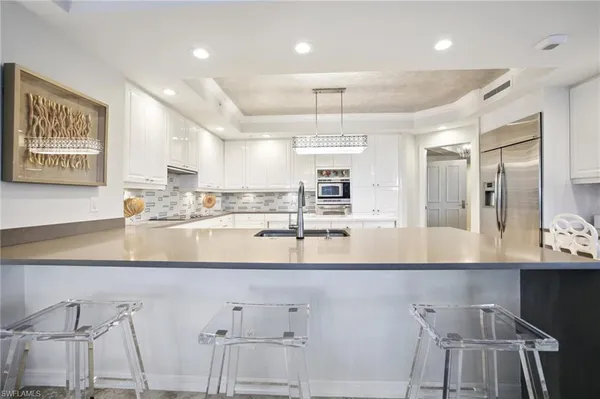 a large kitchen with kitchen island a large counter space and appliances