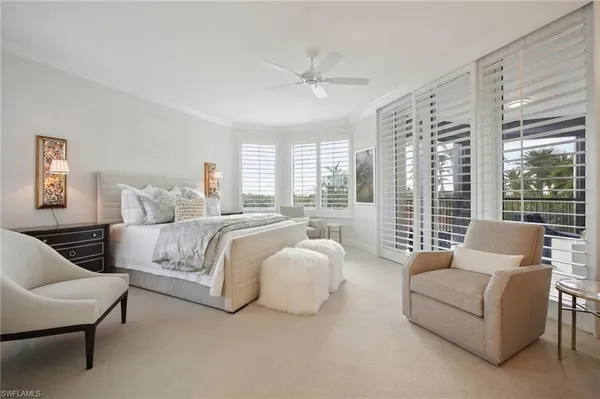 a spacious bedroom with furniture and a large window