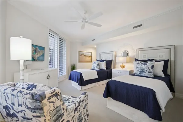 a bedroom with two beds and a large mirror