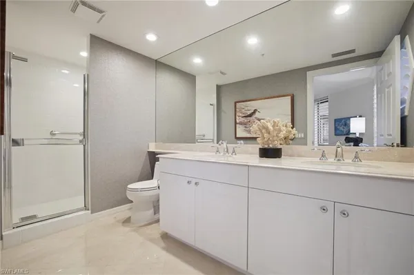 a bathroom with a double vanity sink toilet and a mirror