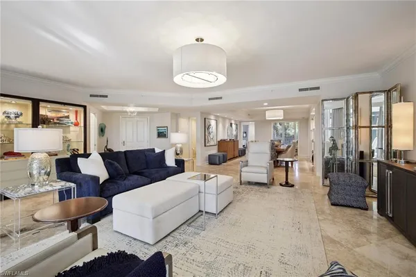 a living room with furniture kitchen view and a window