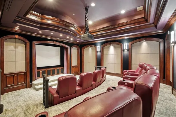a media room with lots of chairs and a chandelier