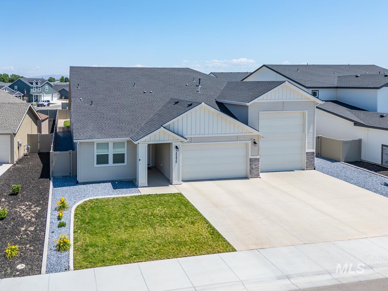 20430 Pitkin Way Caldwell, ID 83605 - Photo 1 of 23 View of front of home featuring board and batten siding, a garage, a shingled roof, and driveway