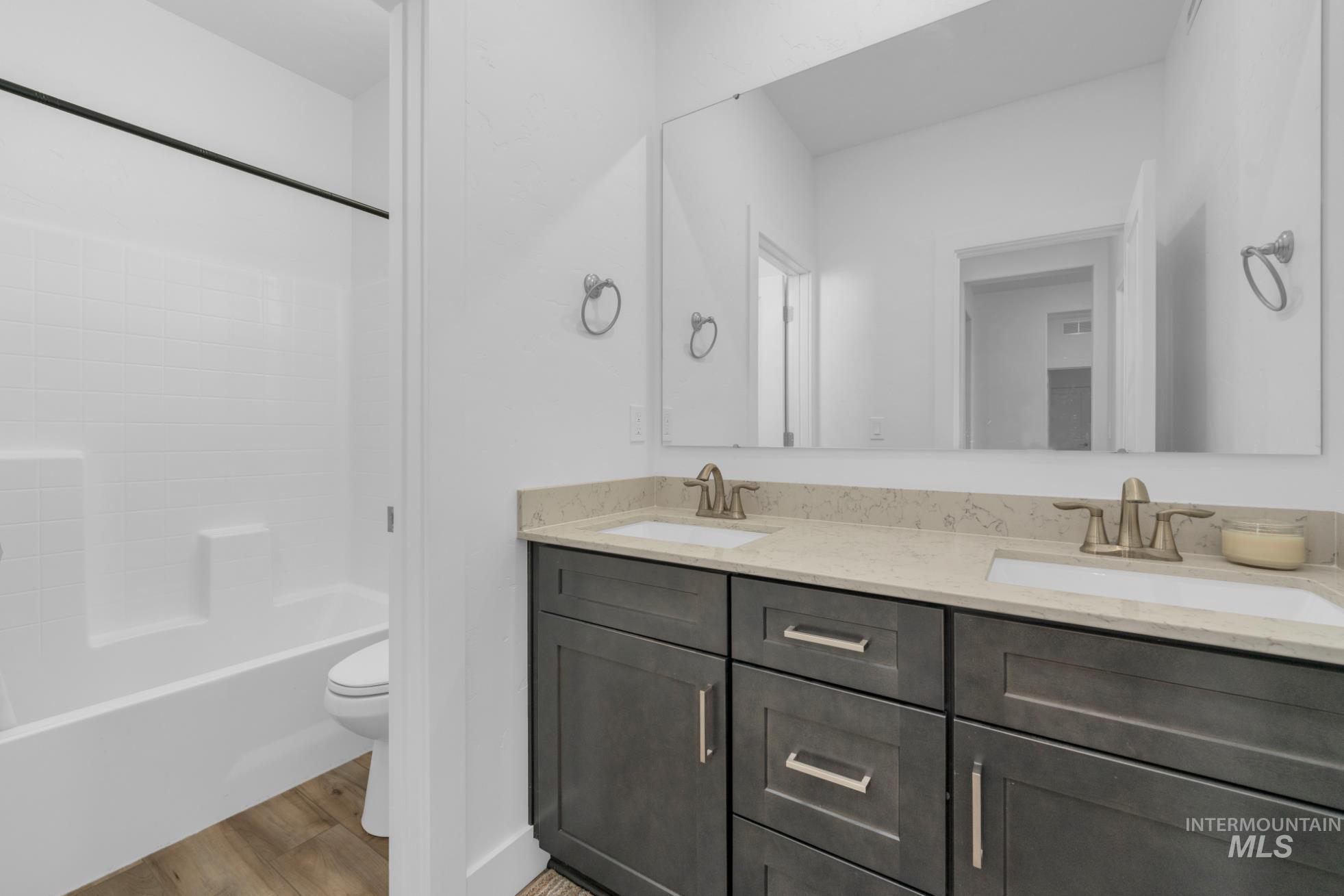 20430 Pitkin Way Caldwell, ID 83605 - Photo 12 of 23 Bathroom with double vanity, wood finished floors, and shower / tub combination
