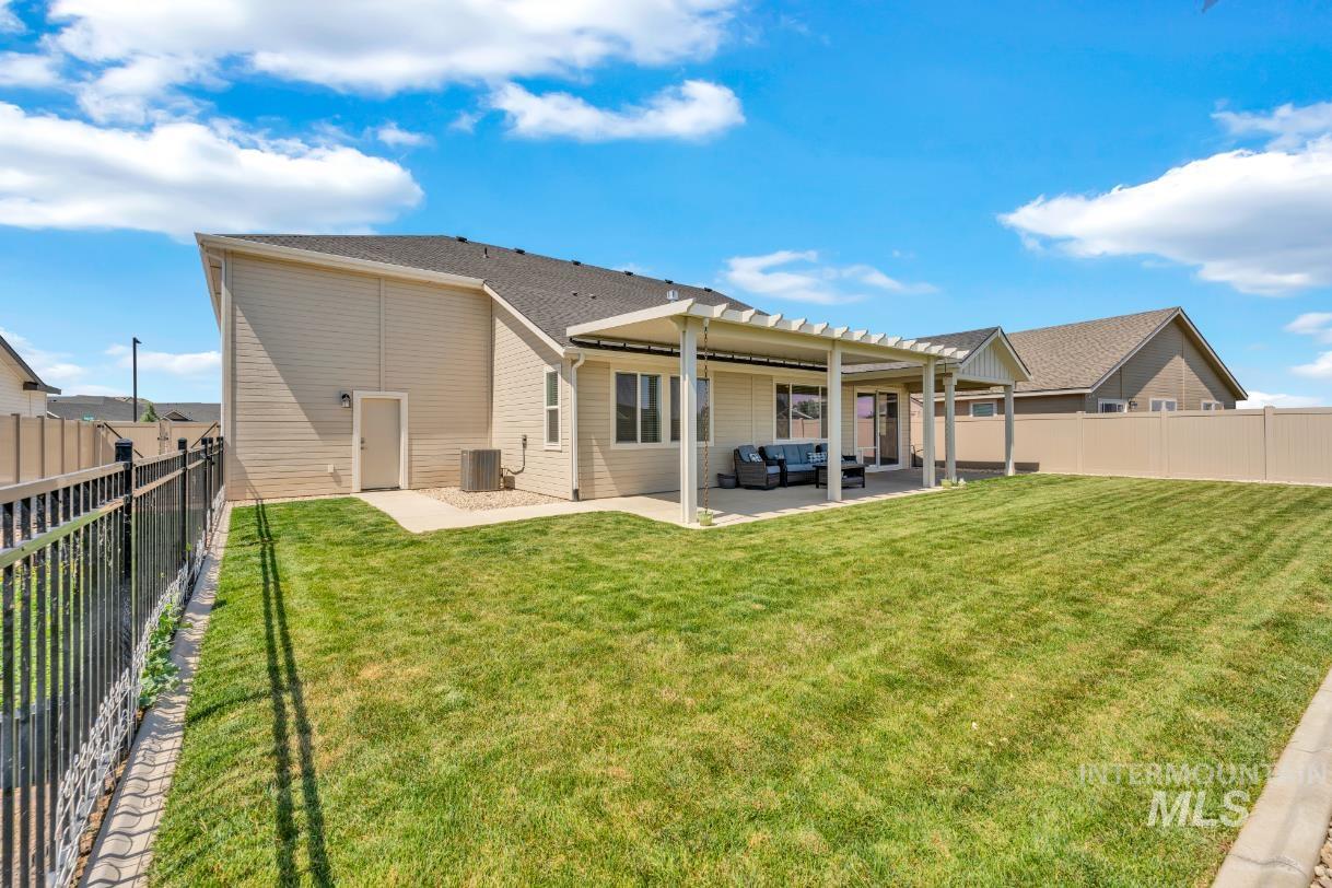 20430 Pitkin Way Caldwell, ID 83605 - Photo 17 of 23 Rear view of property featuring outdoor lounge area, a patio, a fenced backyard, and a pergola