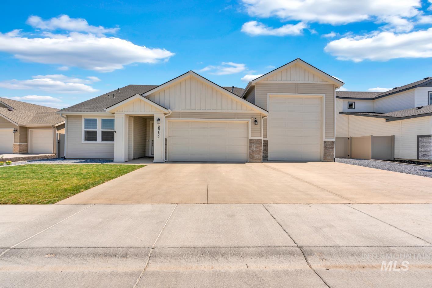 20430 Pitkin Way Caldwell, ID 83605 - Photo 23 of 23 Ranch-style house featuring a garage, concrete driveway, a front lawn, and board and batten siding
