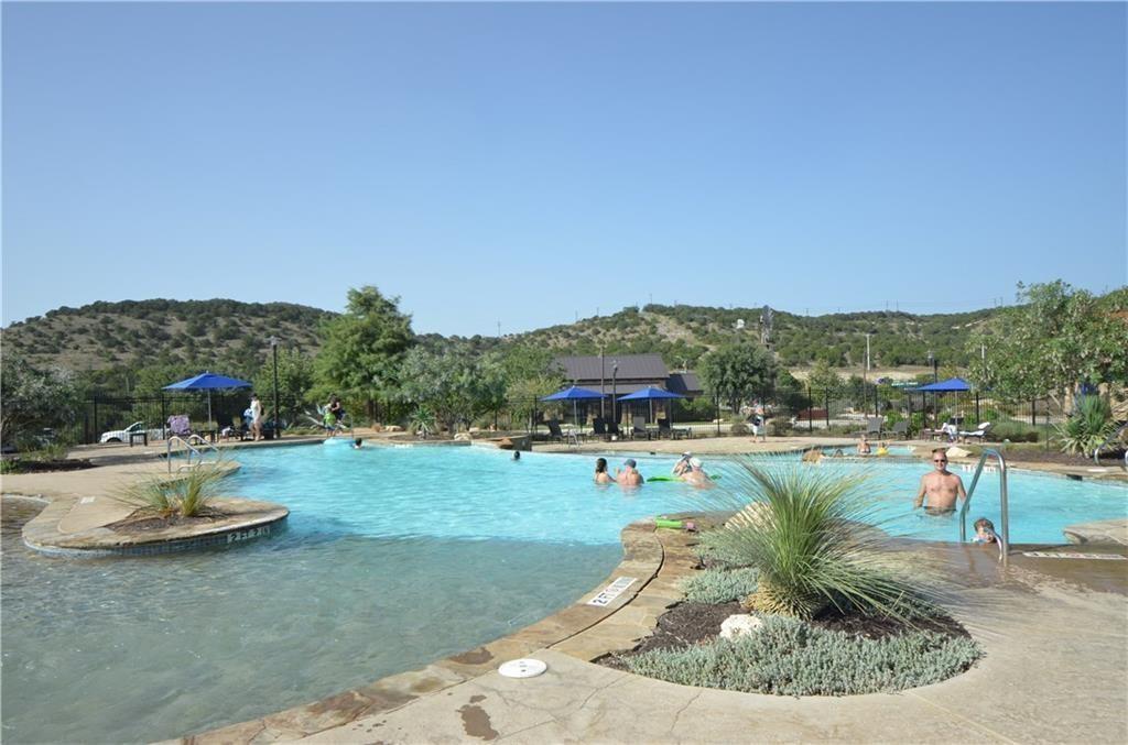 5629 Rio Chama Cove Austin, TX 78738 - Photo 26 of 34 A spacious resort-style pool with integrated sun shelf provides recreation amidst a hilly, treed landscape.