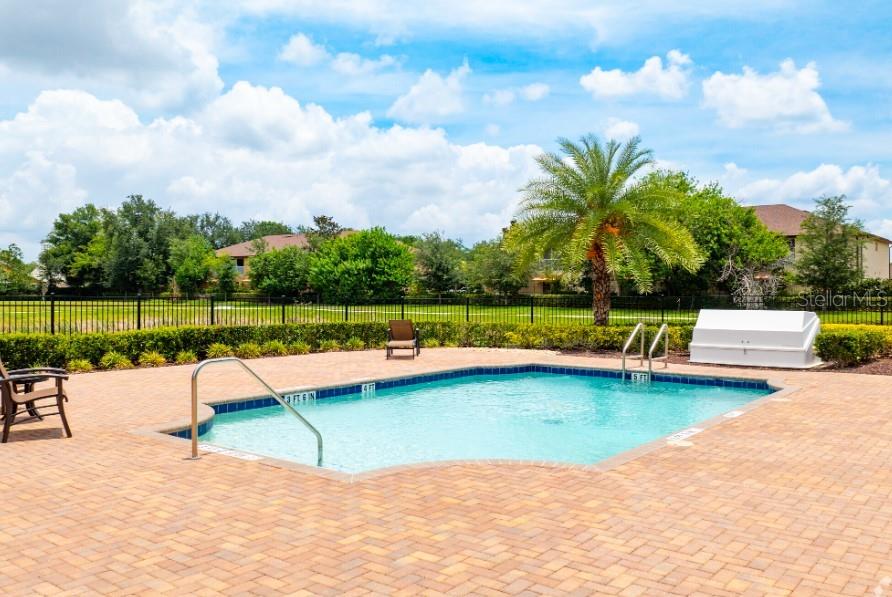 2116 Broome Street Kissimmee, FL 34743 - Photo 16 of 16 a view of a swimming pool with a garden and trees
