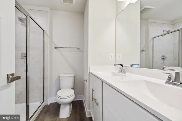 a bathroom with a toilet sink a mirror and shower