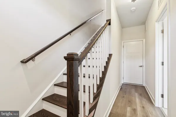 a view of staircase with wooden floor and white walls