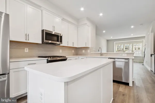 a kitchen with granite countertop white cabinets and white appliances