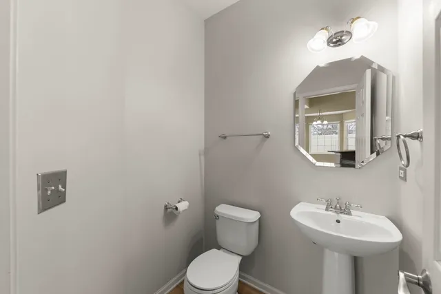 a bathroom with a toilet a sink and mirror