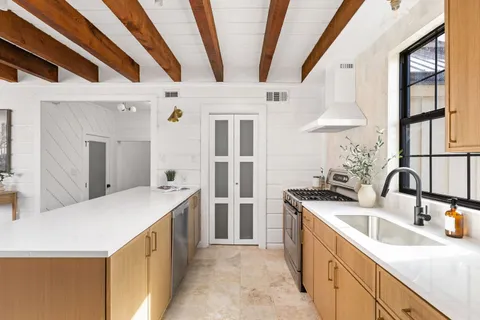 a kitchen with stainless steel appliances granite countertop a sink and a refrigerator