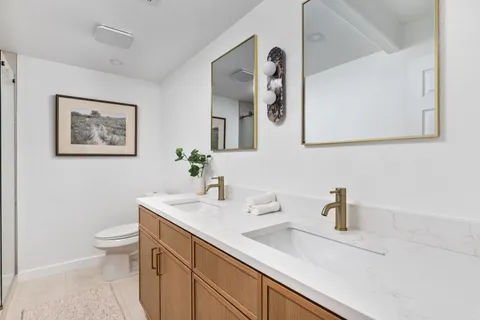 a bathroom with a sink a toilet and a mirror