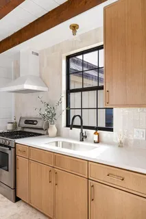a kitchen with stainless steel appliances granite countertop a sink a stove and a wooden floors