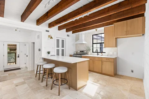 a kitchen with sink cabinets and dining table chair