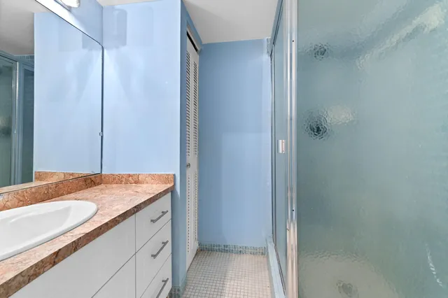 a bathroom with a granite countertop sink and a mirror