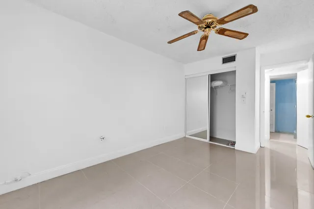 an empty room with a ceiling fan and a window