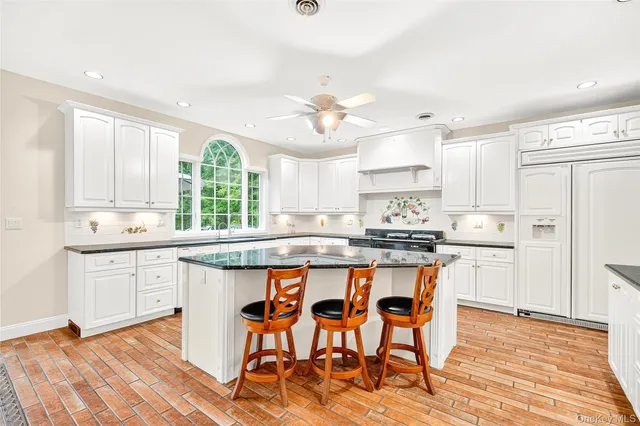 a kitchen with stainless steel appliances granite countertop a table chairs sink refrigerator and cabinets