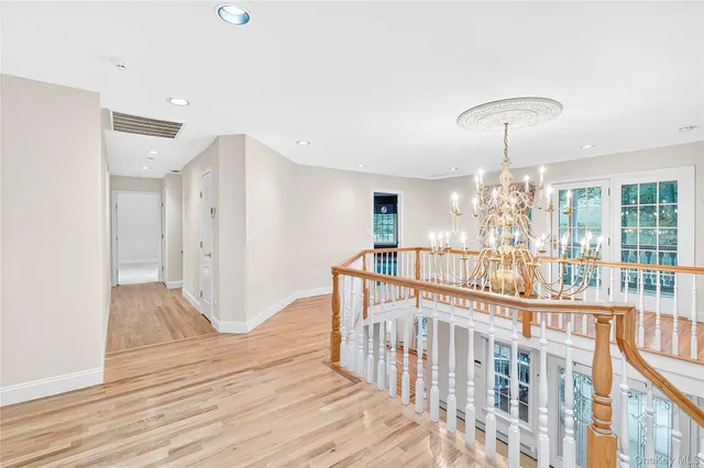 a view of a room with wooden floor fan and windows