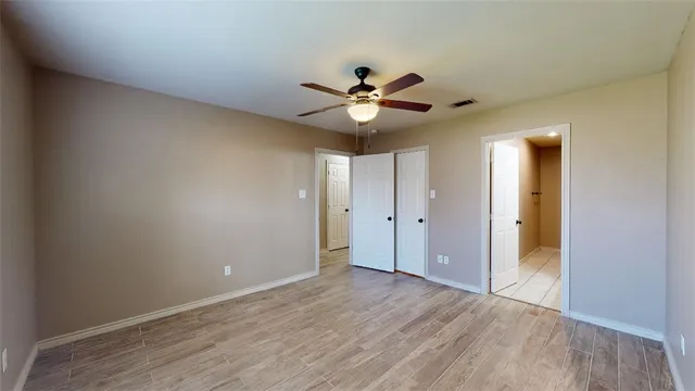 a view of an empty room and a ceiling fan window