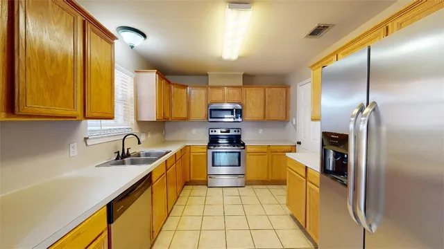 a kitchen with stainless steel appliances granite countertop a sink refrigerator and microwave