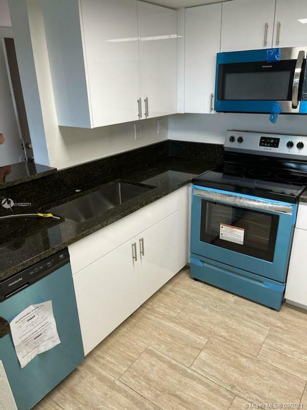 Welleby Sunrise, FL 33351 - Photo 6 of 9 a kitchen with stainless steel appliances a stove a microwave a sink and cabinets