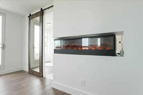 a view of a living room with wooden floor and a window