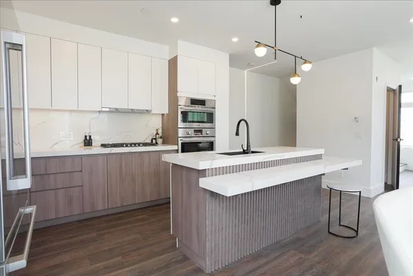 a kitchen with a sink cabinets and wooden floor