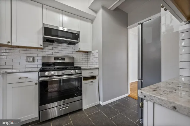 a kitchen with stainless steel appliances granite countertop a stove microwave and refrigerator