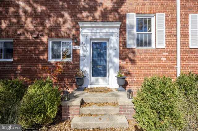 a view of a brick house with potted plants