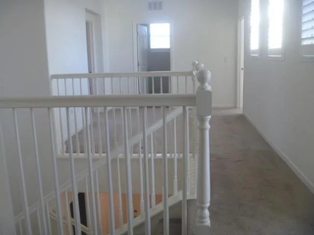 a view of staircase with railing and a window