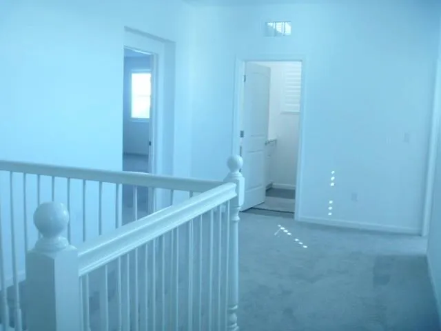 a view of staircase with railing and a window